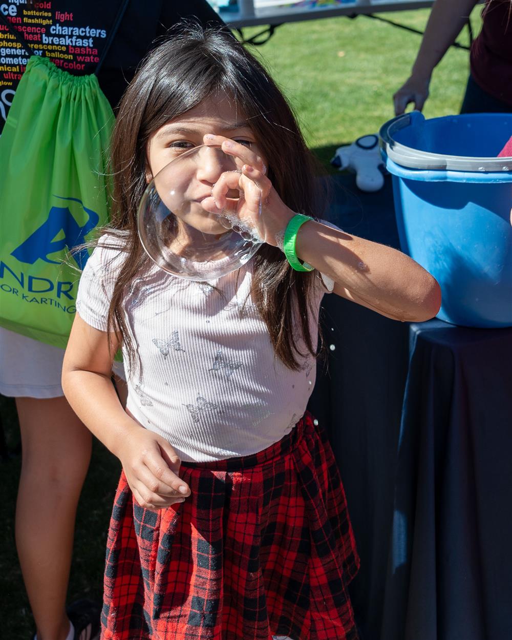 An image of a child blowing a bubble.
